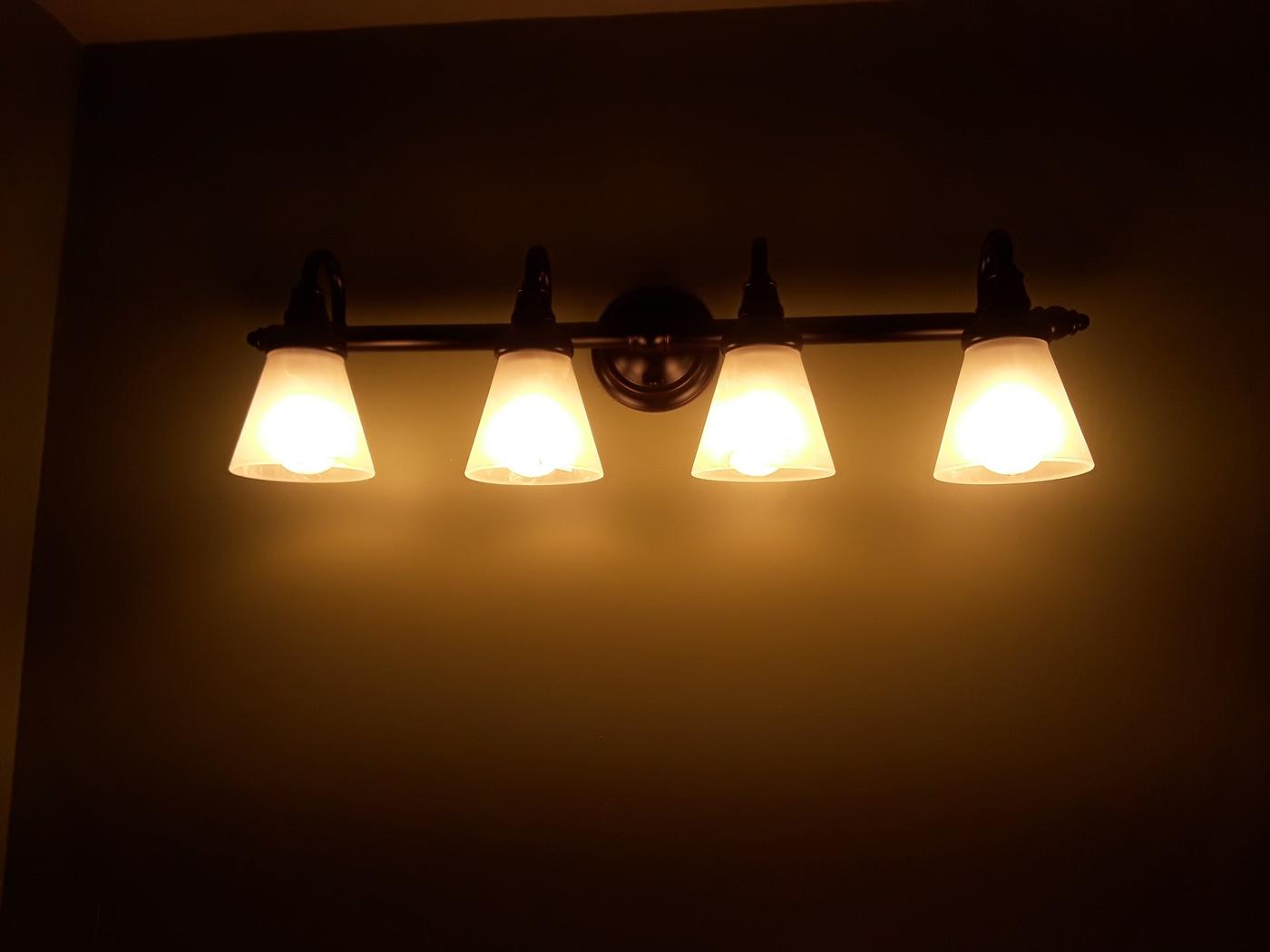 A four shade vanity light bar installed and lit
