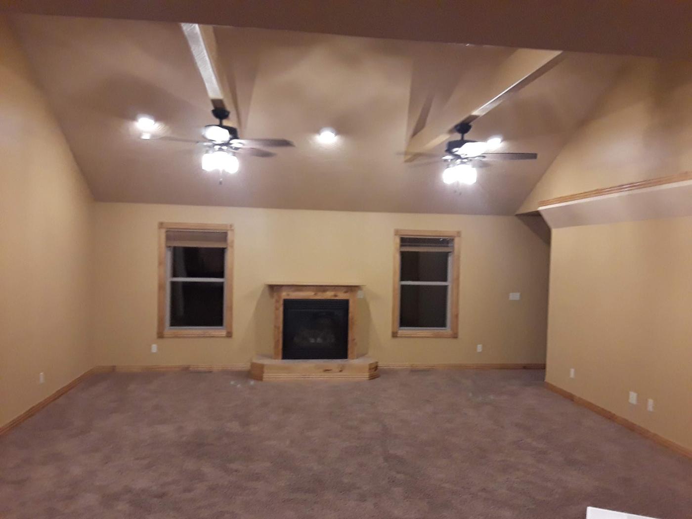 A vaulted room with two ceiling fans and recessed lighting